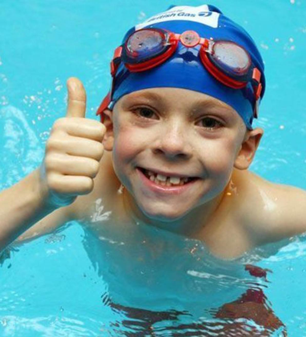 Boy In Pool With Swim Cap amd Goggles Doing the Thumbs Up Sign